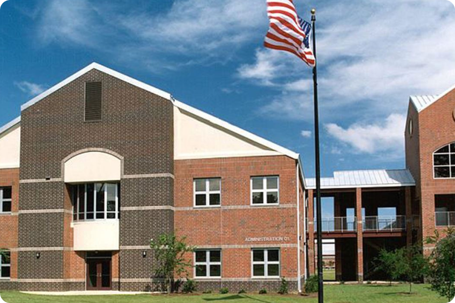 front of school building with american flag out front